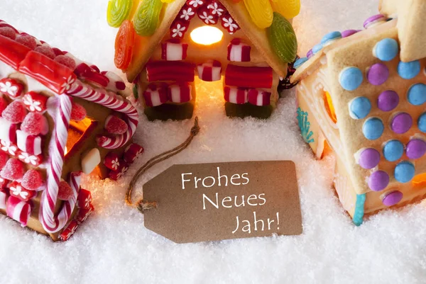 Casa de pão de gengibre colorido, neve, Frohes Neues significa feliz ano novo — Fotografia de Stock