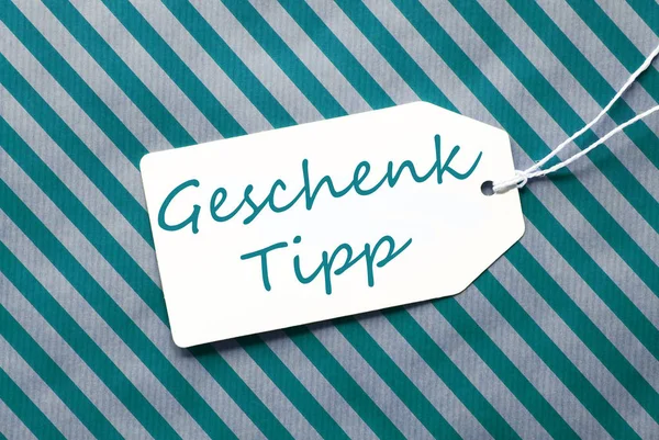 Étiquette sur papier d'emballage turquoise, Geschenk Tipp signifie conseil cadeau — Photo