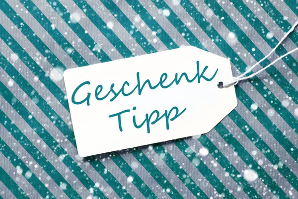 Étiquette, Papier d'emballage turquoise, Geschenk Tipp signifie conseil cadeau, Flocons de neige — Photo