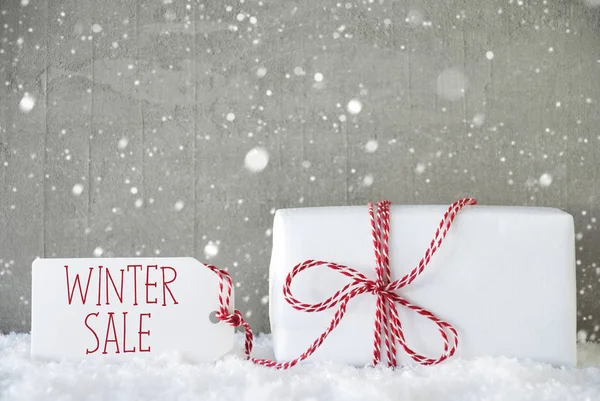 Geschenk, Zementhintergrund mit Schneeflocken, Text Winterschlussverkauf — Stockfoto