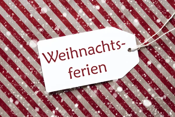 Etichetta su carta rossa, fiocchi di neve, Weihnachtsferien significa pausa natalizia — Foto Stock