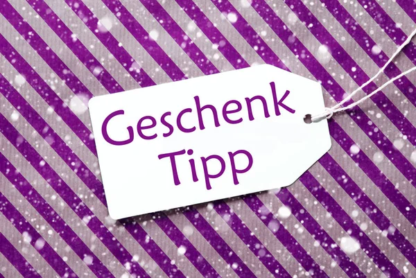 Étiquette, Papier d'emballage violet, Geschenk Tipp signifie conseil cadeau, Flocons de neige — Photo