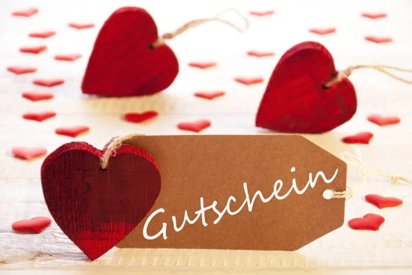 Çok kırmızı kalp, Gutschein demektir fiş etiketle — Stok fotoğraf