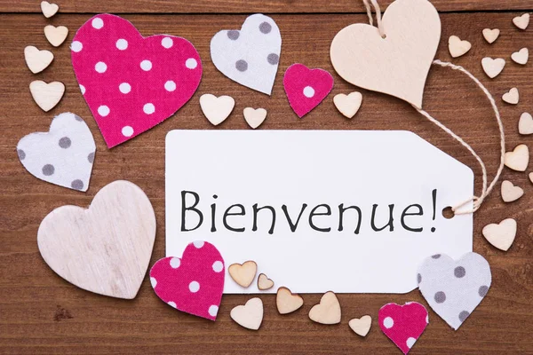 Címke, rózsaszín szívekkel szöveg Bienvenue eszközök Üdvözöljük — Stock Fotó