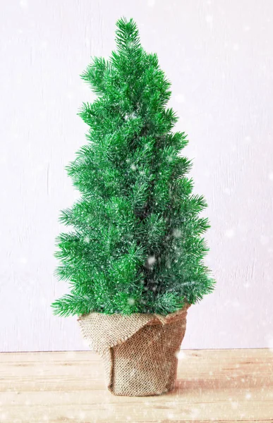 Vertikální vánoční stromeček, růžové Cement pozadí, vločky — Stock fotografie