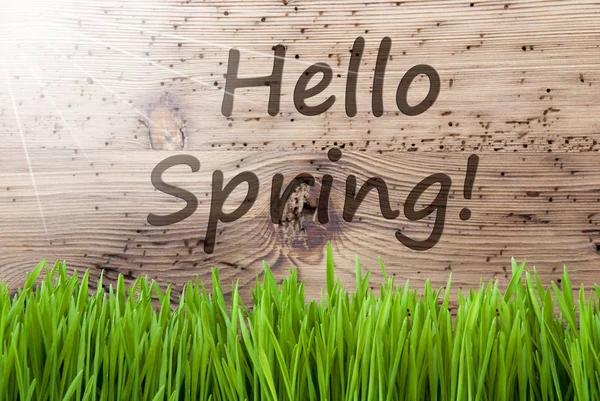 Lichte zonnige houten achtergrond, Gras, tekst Hello Spring — Stockfoto