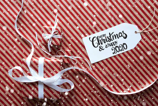 Trzy prezenty, papier do pakowania, etykieta Wesołych Świąt i Szczęśliwych 2020, Płatki śniegu — Zdjęcie stockowe