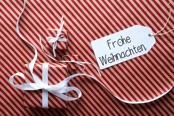 Drei Geschenke, Geschenkpapier, Etikett frohe Weihnachten bedeuten frohe Weihnachten — Stockfoto