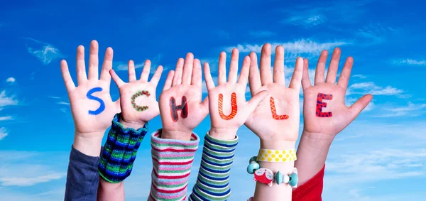 Bambini mani costruzione Word Schule significa scuola, cielo blu — Foto Stock