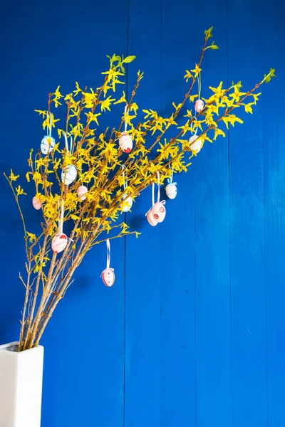 Branche avec des fleurs jaunes, oeuf de Pâques, décoration de printemps, fond bleu — Photo