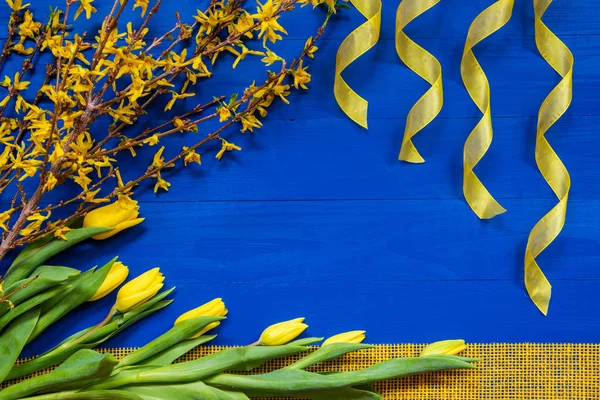 Flores amarelas da tulipa e ramo da Páscoa, fita, fundo azul — Fotografia de Stock