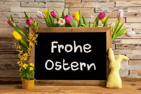Fleurs de tulipes, lapin, mur de briques, tableau noir, texte Frohe Ostern signifie Joyeuses Pâques — Photo