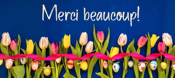 Banner com tulipa colorida, Merci Beaucoup significa obrigado, ovo de Páscoa — Fotografia de Stock