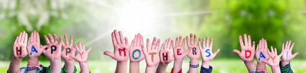 Παιδιά Χέρια οικοδόμηση λέξη ευτυχισμένη ημέρα μητέρων, γρασίδι λιβάδι — Φωτογραφία Αρχείου