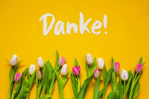 Barevný tulipán, Text Danke znamená děkuji, žluté pozadí — Stock fotografie