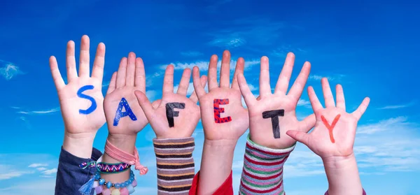 Las manos de los niños construyendo la palabra seguridad, cielo azul — Foto de Stock