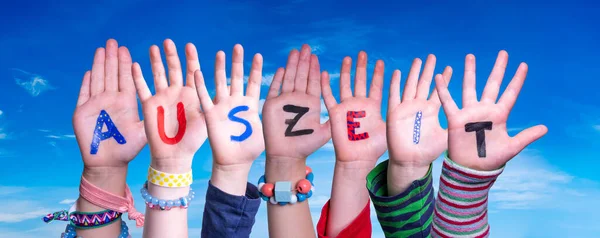 Manos de los niños Construyendo la Palabra Auszeit significa tiempo de inactividad, cielo azul — Foto de Stock
