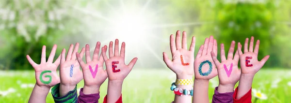 Kinderhände bauen Wort geben Liebe, Graswiese — Stockfoto