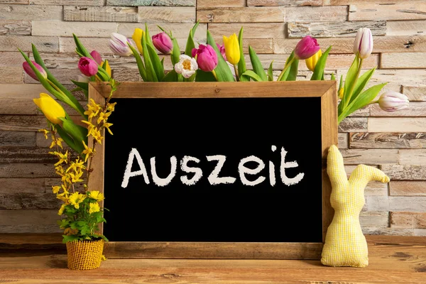 Flores da tulipa, coelho, parede de tijolo, quadro negro, texto Auszeit significa tempo de inatividade — Fotografia de Stock