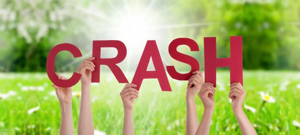La gente sostiene la palabra Crash, prado de hierba — Foto de Stock