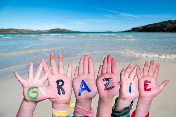 Mani dei bambini Costruzione parola Grazie significa grazie, sfondo dell'oceano — Foto Stock