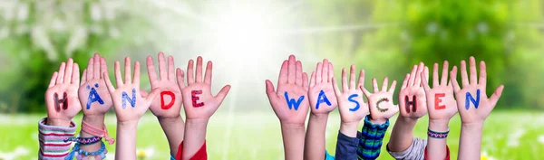 Kinderen handen vasthouden woord haende Waschen betekent wassen uw handen, Grasveld — Stockfoto