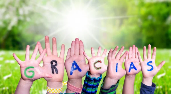 Barn händer Bygga ord Gracias innebär Tack, Gräs äng — Stockfoto