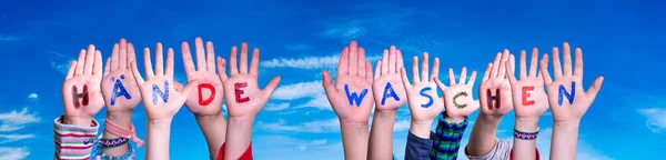 Dzieci Ręce trzymające słowo Haende Waschen oznacza umyj ręce, Blue Sky — Zdjęcie stockowe