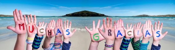 Kinderhände Word bauen Muchas Gracias bedeutet Danke, Ocean Background — Stockfoto