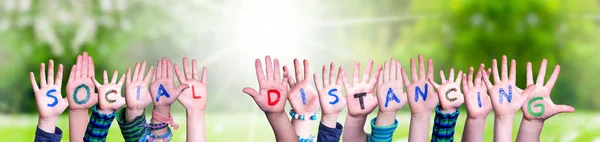 Kinderen handen bouwen woord sociale afstand, Grasveld — Stockfoto
