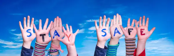 Παιδιά χέρια κρατώντας λέξη Μείνετε ασφαλείς, Blue Sky — Φωτογραφία Αρχείου