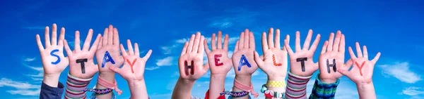 Kinderen handen houden woord blijf gezond, Blue Sky — Stockfoto