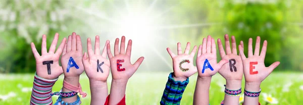 Dzieci Ręce Budowanie słowa Take Care, łąka trawy — Zdjęcie stockowe