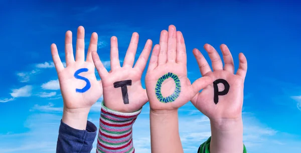 Bambini mani che costruiscono Word Stop, cielo blu — Foto Stock