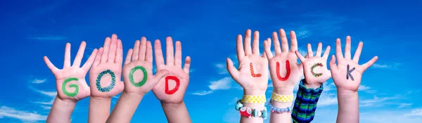 Dětské ruce drží slovo Hodně štěstí, modrá obloha — Stock fotografie