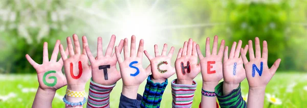 子供の手を構築する単語Gutscheinはバウチャー、草の牧草地を意味します — ストック写真