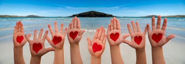 Gyerekek kéz szív szimbólum, óceán és a strand, mint a háttérben — Stock Fotó