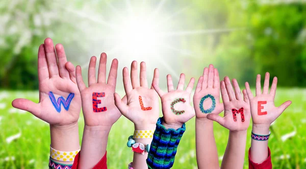 Muitas crianças mãos construindo palavra Bem-vindo, Grass Meadow — Fotografia de Stock