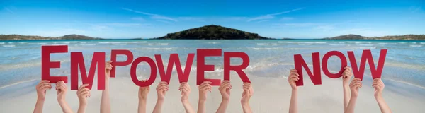 Le persone mani in possesso di Word Empower Now, Oceano sfondo — Foto Stock