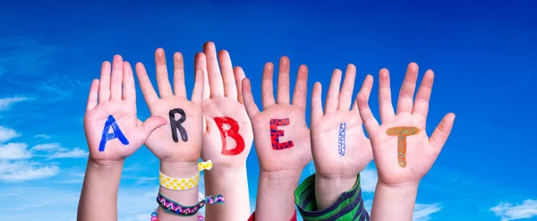 Mani dei bambini che costruiscono parola Arbeit significa lavoro, cielo blu — Foto Stock