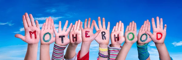 Gyerekek kezek építő szó anyaság, kék ég — Stock Fotó