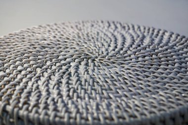 Merkezde yoğunlaşan sarmal saman dokuma, açık gri doğal renklerde simetrik konsantrasyon sağlar. Ekomateryal kavramı, el yapımı, şablon tasarımı.