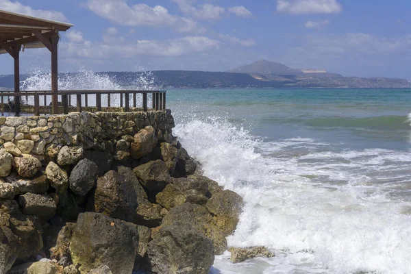 顶部有栅栏的石头海滨 海浪在岩石上冲撞 美丽的海景与遥远的岛屿 — 图库照片