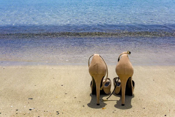 Para Beżowych Butów Wysokich Obcasach Pozostawionych Piaszczystej Plaży Pobliżu Morza Obraz Stockowy