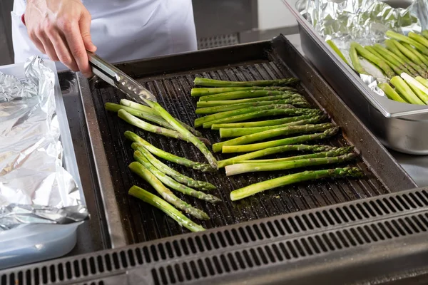 Un puñado de espárragos verdes cocinando y al vapor en la parrilla — Foto de Stock