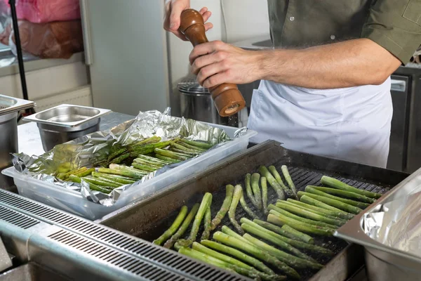 Un puñado de espárragos verdes cocinando y al vapor en la parrilla — Foto de Stock