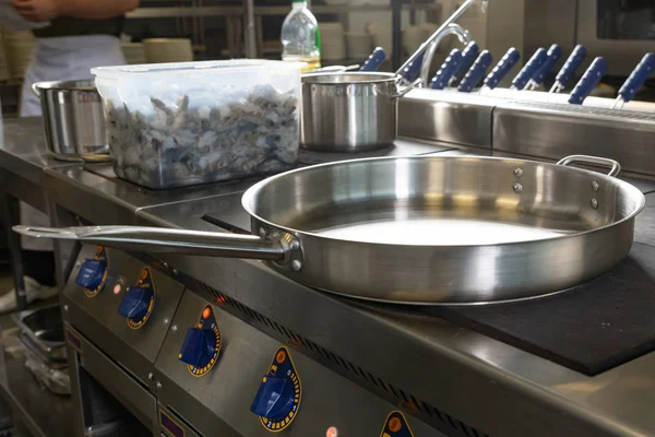 Gran puesto de la sartén en los azulejos en la cocina del restaurante. El concepto del negocio de los restaurantes. Foto en el interior . — Foto de Stock