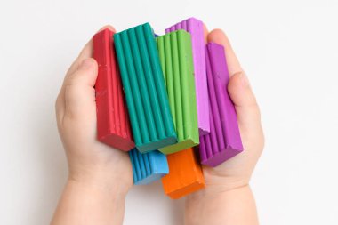 plasticine in children's hands on a white background close up