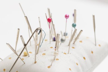 Ev yapımı yastık dikiş ve güvenli depolama için çok sayıda şırıngayla bej paralondan iğneler saplamak için..