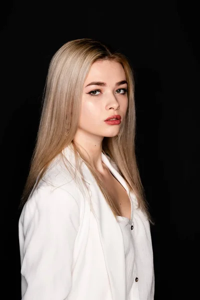 Close up portrait of beautiful young model with blonde hair and black clothes, posing in photostudio on dark background — Stock Photo, Image